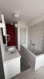 a white bathroom with a tub and a sink at Poziom Morza in Gdynia +5 photos