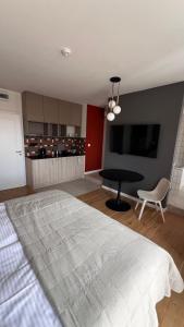 a bedroom with a bed and a table and a tv at Poziom Morza in Gdynia