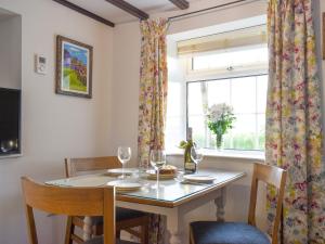 a dining room with a table and chairs and a window at New Cottage in Egton