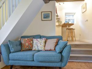 a blue couch with pillows in a living room at New Cottage in Egton