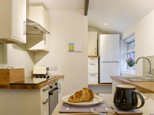 a kitchen with a plate of bread on a counter at New Cottage in Egton +9 photos