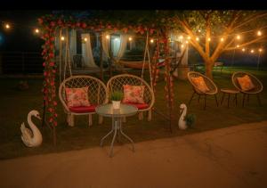 a group of chairs and a table under a gazebo with lights at The Garden Apartments in Nea Kallikrateia
