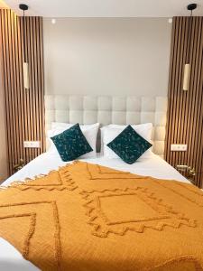 a bed with an orange blanket and pillows on it at Raiano Guest House in Monção
