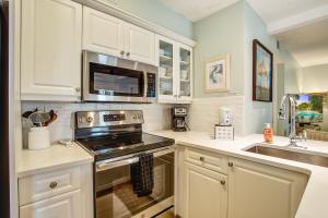 a kitchen with white cabinets and a stove top oven at 1641 Courtside in Seabrook Island +26 photos