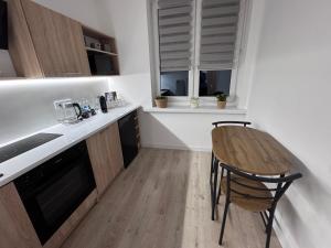 a kitchen with a wooden table and a counter top at Helenka Loft House 24H in Zabrze +6 photos