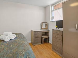 a bedroom with a bed and a desk and a television at Gable End Coastal Retreat in Great Yarmouth