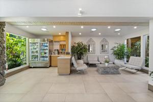 a lobby with white furniture and plants in it at Humphreys Half Moon Inn in San Diego