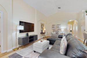 a living room with a leather couch and a flat screen tv at Cumbrian Lakes Villa in Kissimmee