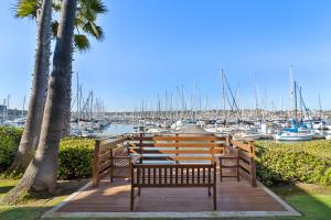 two benches sitting on a wooden deck near a marina at Humphreys Half Moon Inn in San Diego