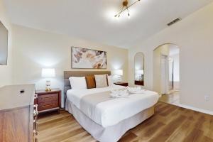 a bedroom with a large white bed and a dresser at Cumbrian Lakes Villa in Kissimmee +21 photos