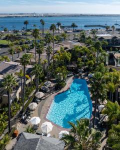 an aerial view of a resort pool with palm trees and the ocean at Humphreys Half Moon Inn in San Diego