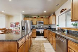 a kitchen with wooden cabinets and stainless steel appliances at Bobsled Haven in Park City