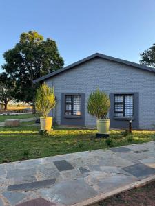 una casa con dos macetas delante de ella en Reunion Vacations - Milk 'n Honey, en Vosburg 74 fotos más