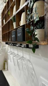 a row of wine glasses hanging on a wall at La bottega di zia Tetta - Luxury Home in Ceglie Messapica