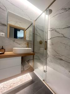 a bathroom with a sink and a shower at Raiano Guest House in Monção