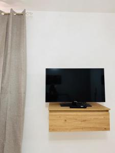 a flat screen tv sitting on a stand next to a curtain at Casa Vacanze Chi mi cunti in Noto