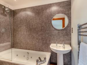 a bathroom with a tub sink and a mirror at 4 Bed in Westward Ho 91814 in Northam +28 photos