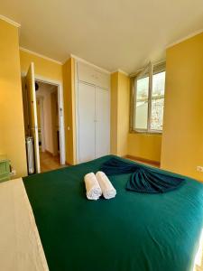 1 dormitorio con 1 cama verde y 2 almohadas en Casa do Castelo, en Lisboa