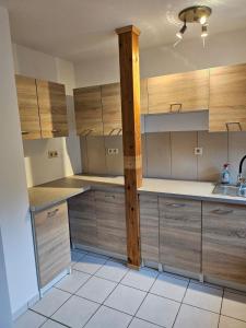 a kitchen with wooden cabinets and a sink at Waldeslust Pension in Oelde