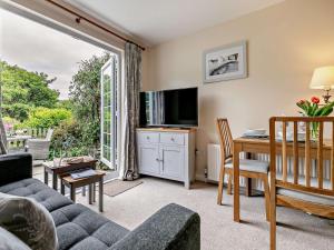 a living room with a couch and a table and a television at 1 Bed in Perranporth COLMA in Perranporth