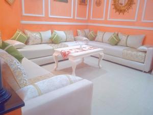 a living room with white couches and a coffee table at Wifa9 in Temara
