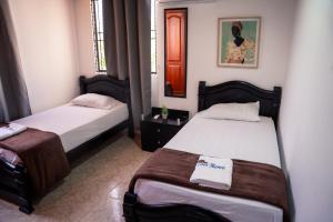 two beds in a small room with two beds sidx sidx sidx at Casa Blanca Increíble Casa Completa Valledupar in Valledupar