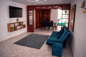 a living room with a blue couch and a television at Casa Marina Espectacular Casa Completa Valledupar in Valledupar