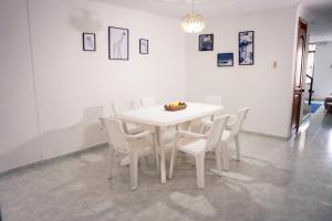 a white table and chairs in a room at Casa Salmón Confortable Casa Completa Valledupar in Valledupar