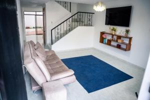 a living room with a couch and a blue rug at Casa Salmón Confortable Casa Completa Valledupar in Valledupar
