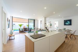 an open kitchen and living room with a large island at Saras Village in Adeje