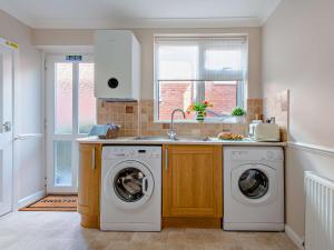 a kitchen with a washing machine and a sink at 2 Bed in Swanage 90116 in Swanage +6 photos