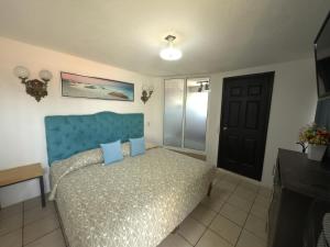 een slaapkamer met een bed met een blauw hoofdeinde bij Hotel Casa ixtapan in Ixtapan de la Sal +36 foto's