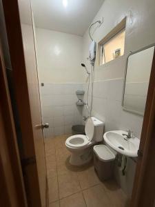 um banheiro com vaso sanitário e pia em Wonderfully cozy apartment em Tagum