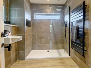 a bathroom with a shower and a sink at 4 Bed in Weybourne 91228 in Weybourne +21 photos
