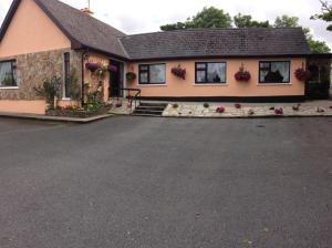 a house with flowers in front of it at Eriu Lodge in Clifden