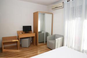ein Schlafzimmer mit Schreibtisch, Computer und Stuhl in der Unterkunft Hotel Ribadouro in Alijó