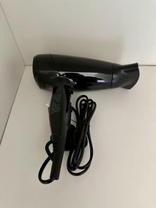a black hair dryer sitting on top of a counter at 43 Deluxe London Ensuites in London