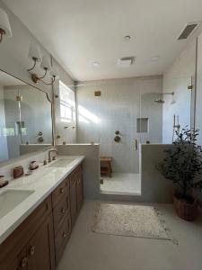 a bathroom with a shower and a large mirror at Beach Oasis in Carlsbad Village in Carlsbad