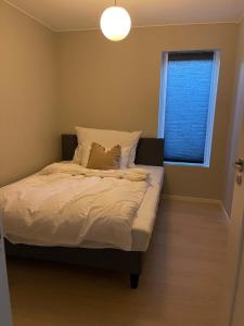 a bedroom with a bed and a window with a light at Semi-detached house with lovely views of the city fjord in Askøy