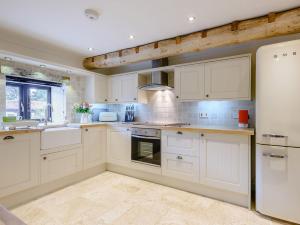 a kitchen with white cabinets and white appliances at 3 bed in Winterton-on-Sea 77582 in Hickling
