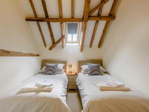 two beds in a room with wooden beams at 3 bed in Winterton-on-Sea 77582 in Hickling