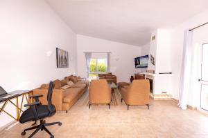 a living room with a couch and chairs and a table at Carpe Diem in Faro