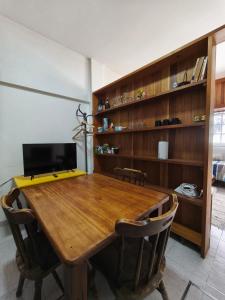 a wooden table with chairs and a laptop on it at Hogar Argentina 2 in Quilmes
