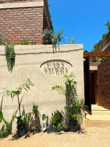 a sign that says whatever on a wall with plants at Casa Xaviera in Puerto Escondido