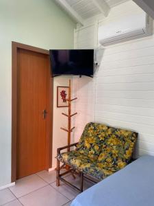 インビトゥバにあるMorada Alto Astralのドア付きの部屋に椅子が備わる部屋