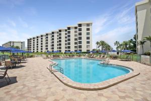 a pool with chairs and umbrellas and a hotel at Luxurious 2BR Gulfview Condo On Siesta Key Steps To The Beach Gulf Horizon in Sarasota