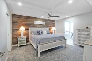 a bedroom with a bed and a wooden accent wall at Luxurious 2BR Gulfview Condo On Siesta Key Steps To The Beach Gulf Horizon in Sarasota +65 photos