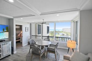 a living room with a table and chairs and a large window at Luxurious 2BR Gulfview Condo On Siesta Key Steps To The Beach Gulf Horizon in Sarasota