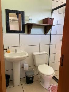 a bathroom with a toilet and a sink and a mirror at Morada Alto Astral in Imbituba +22 photos