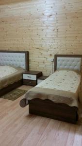 two beds in a room with wooden walls at Hotel Bulaq in Turist